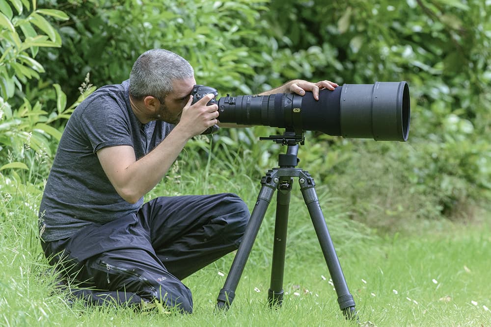 long-lens-using-tripod-kneeling