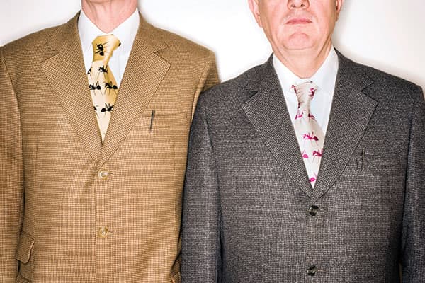 The suits, formal pose and Parker pens identify this pair as Gilbert & George