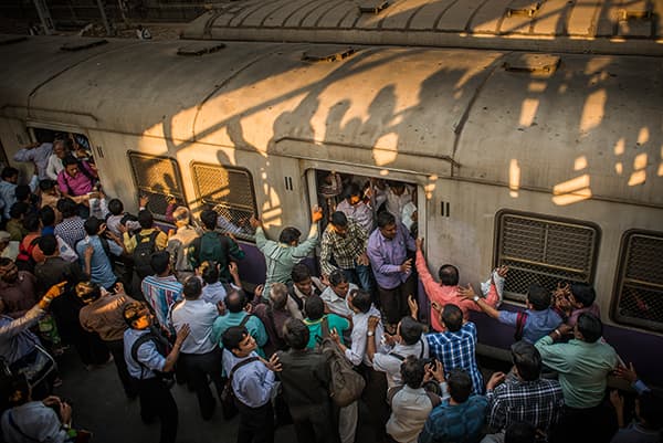 Swathes of men attempt to board an already crammed local train in Mumbai