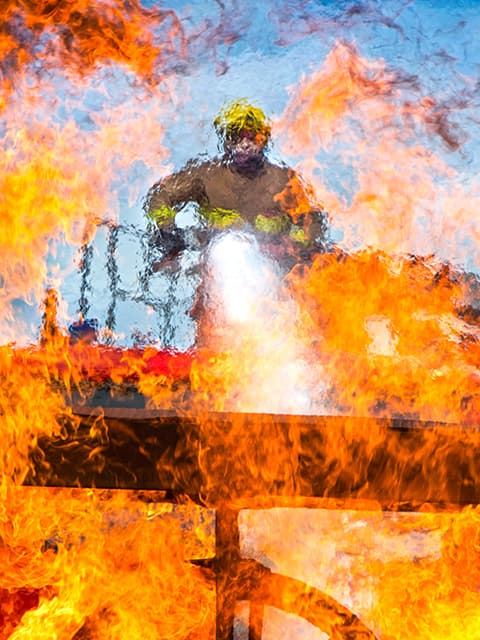 A fireman from RAF Shawbury fire and rescue department extinguishing flames on the station aircraft simulator located on the perimiter of the airfield. The simulator can be used to create many different aircraft fire scenarios in a controled environment